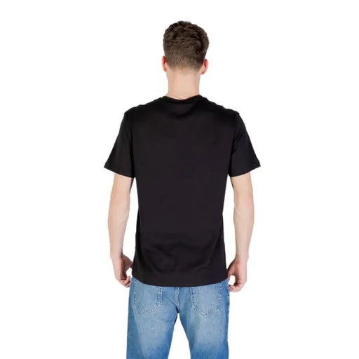 Black crew neck T-shirt paired with blue jeans displayed for a men’s fashion product