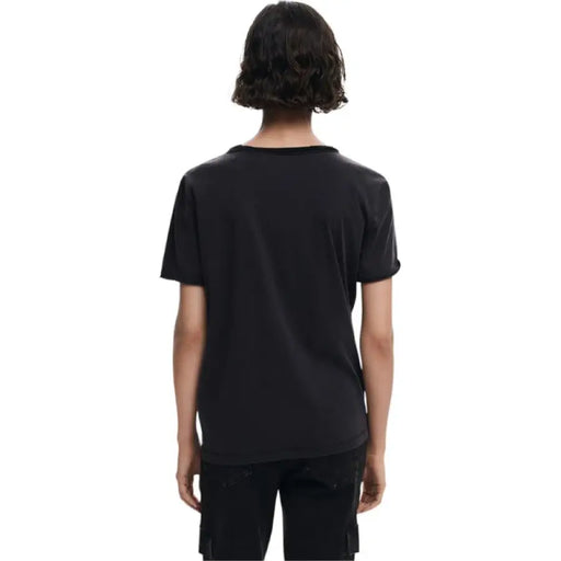 Woman wearing black Mickey Mouse T shirt and cargo pants showcasing casual fashion style