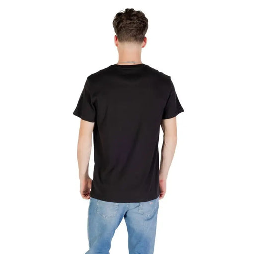 Black Short Sleeve Tommy Jeans T Shirt displayed on a person in a professional setting