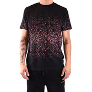 T-shirt noir à manches courtes orné de paillettes roses et blanches qui s'estompent de la poitrine jusqu'à l'ourlet, créant un motif éclaboussé.