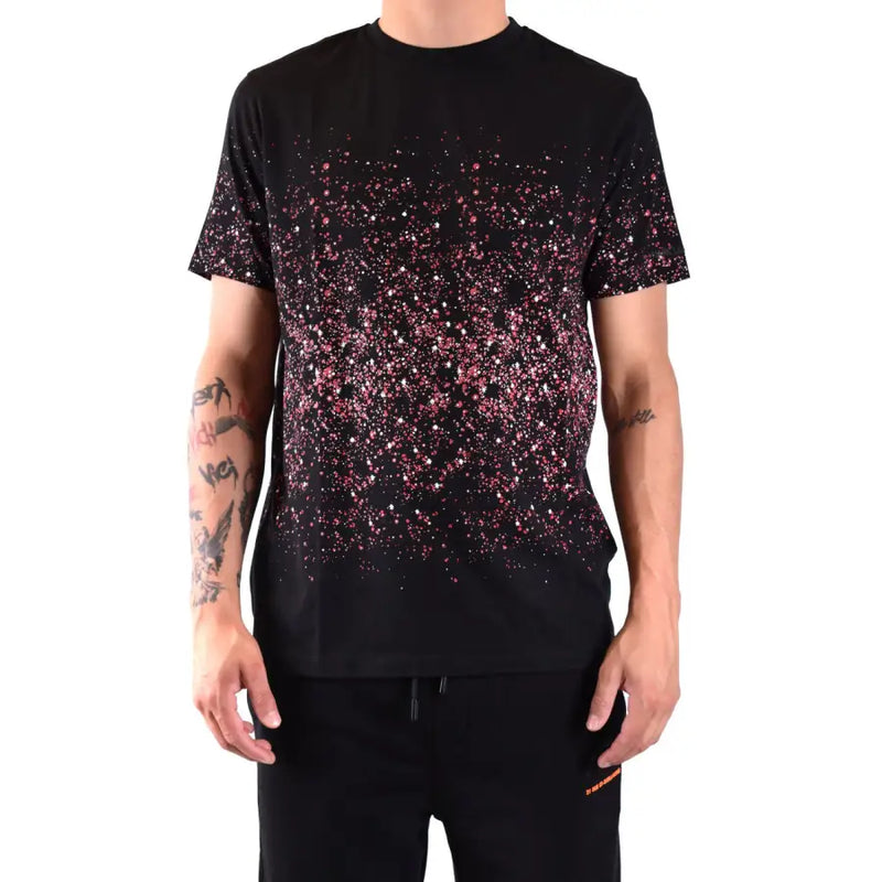 T-shirt noir à manches courtes orné de paillettes roses et blanches qui s'estompent de la poitrine jusqu'à l'ourlet, créant un motif éclaboussé.