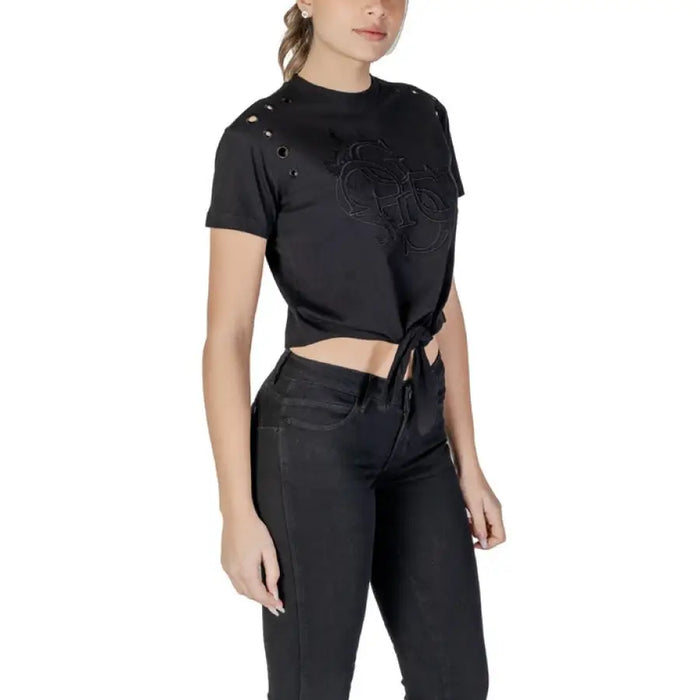 Black tie front T-shirt with grommets paired with jeans for a stylish casual look
