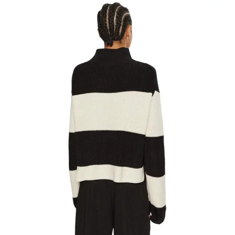 Black and white striped turtleneck sweater displayed in a product image
