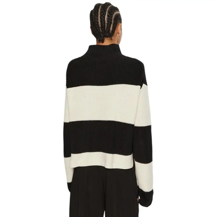 Black and white striped turtleneck sweater displayed in a product image