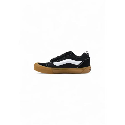 Black and white Vans sneaker with a brown sole displayed in the product image