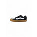 Black and white Vans sneaker with a brown sole displayed in the product image