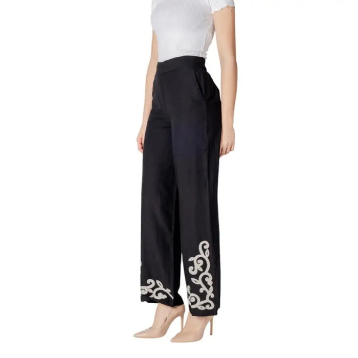 Black wide-leg pants featuring elegant white embroidery on the cuffs