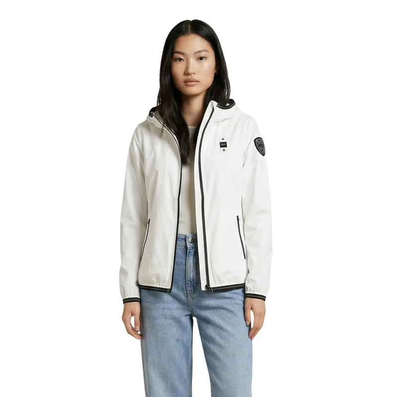 Blauer Veste à capuche blanche pour femme, en nylon élasthanne, avec fermeture éclair noire et petit écusson sur la manche gauche.