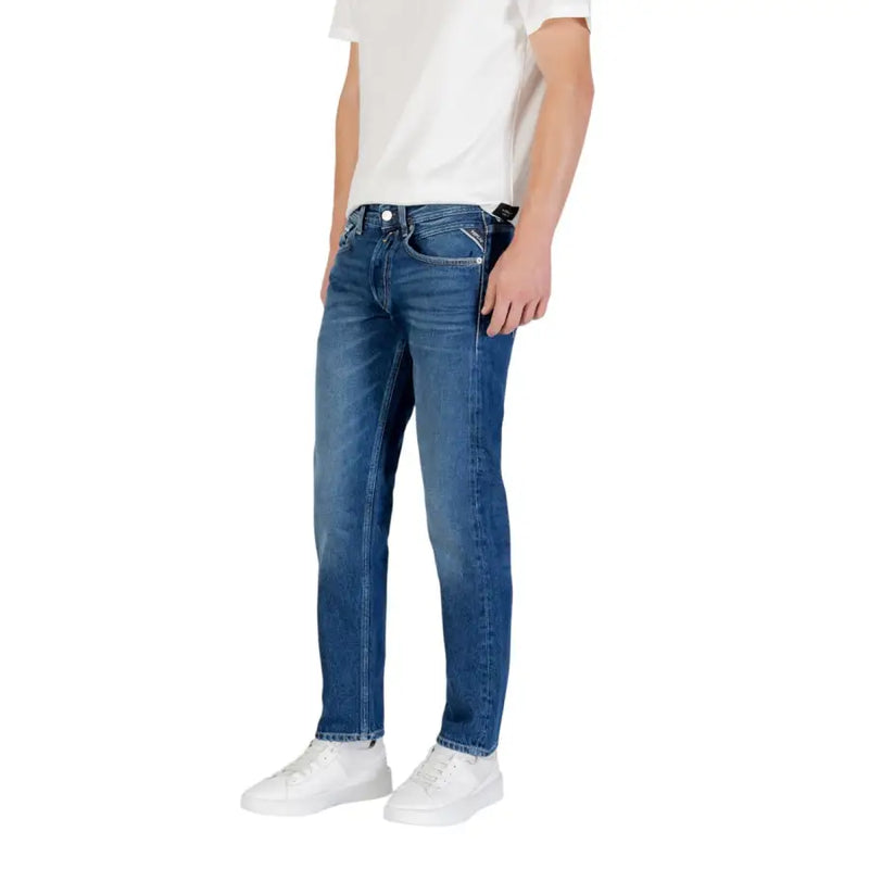 Jean en denim bleu, coupe classique et délavage subtil laissant apparaître l'arrière, avec le logo Calvin Klein sur la poche.