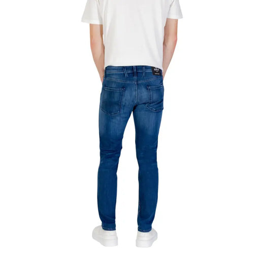 Blue denim jeans displayed with white sneakers in a product exhibit