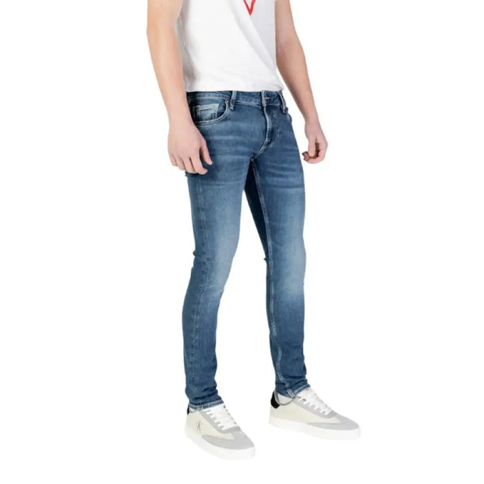 Blue denim skinny jeans from Guess featuring a distressed design for men