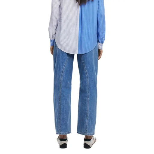 Blue denim wide-leg jeans showcased with a striped long-sleeved button-down shirt