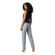 Back view of light-wash denim jeans with straight-leg cut and classic pockets paired with blue sleeveless cotton gilet
