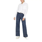 Woman wearing white long-sleeve collared shirt with dark blue speckled wide-leg pants for fall winter fashion