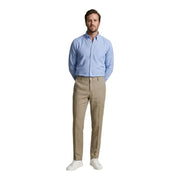 Un homme portant un pantalon Borghese camel 100% lin associé à une chemise bleu clair boutonnée, tenue printemps-été