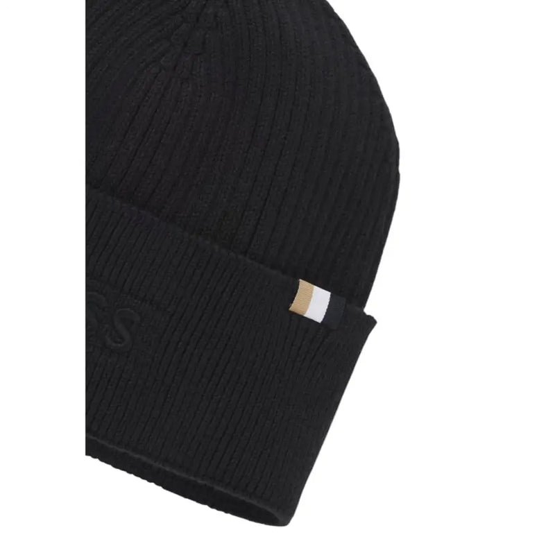 Black beanie with gold label and ribbed texture.