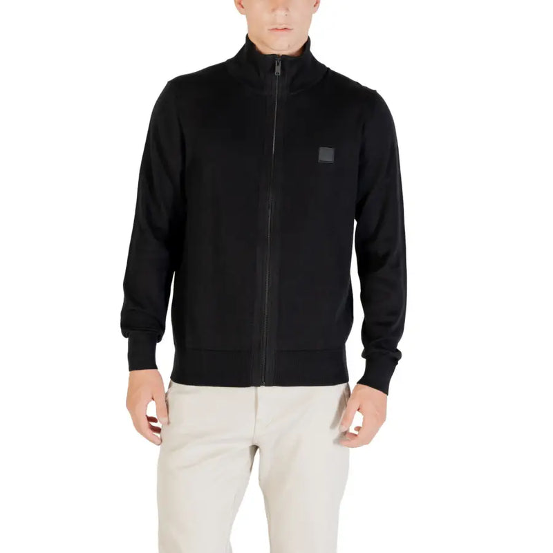 Black zip-up jacket with a square patch on the chest, likely made of cotton or polyester.