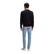 Pull en cachemire noir pour homme, modèle Boss Kanovano, porté sur une chemise blanche à col et un jean bleu clair (vue de face).