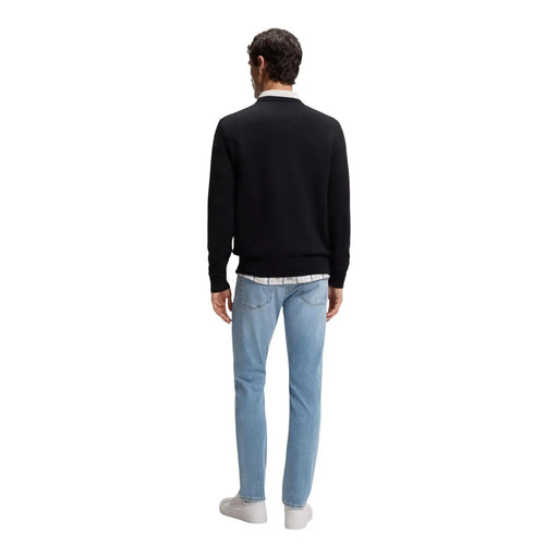 Pull en cachemire noir pour homme, modèle Boss Kanovano, porté sur une chemise blanche à col et un jean bleu clair (vue de face).