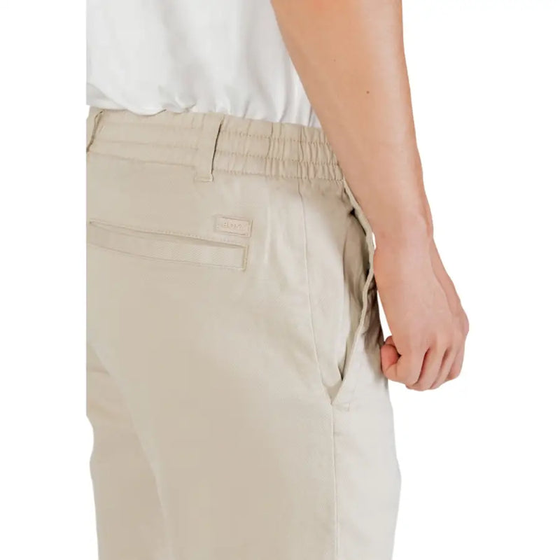 Back view of boss men beige polyester chino pants with elastic waistband and brand tag on the pocket for fall and winter