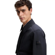 Blazer bleu marine foncé pour homme, coupe classique, veste en polyester à la texture subtile et logo brodé noir sur la manche.