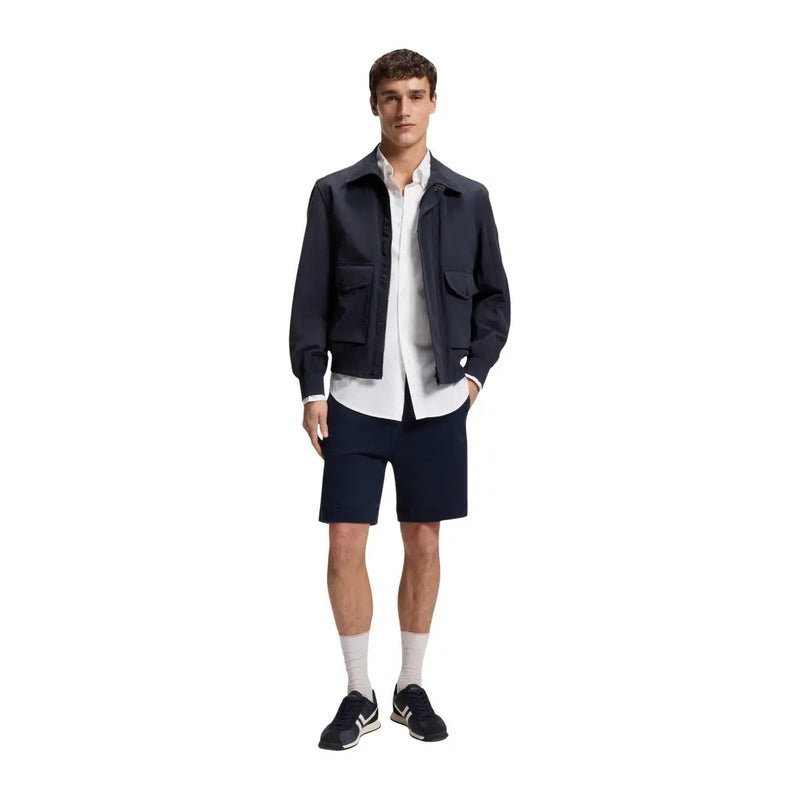 Blazer bleu marine en polyester pour homme, coupe classique, style utilitaire, col et deux poches à rabat sur le devant.