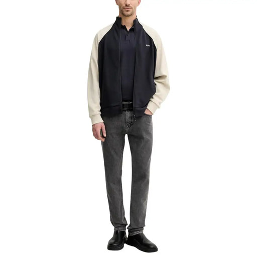 Blouson aviateur bicolore marine et crème, fermeture éclair et logo discret, porté avec un jean gris slim stretch en coton Boss Men.