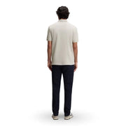 Un homme portant un polo Boss pour homme, gris émeraude, en coton, à col zippé, manches courtes, col classique beige clair et coutures apparentes.