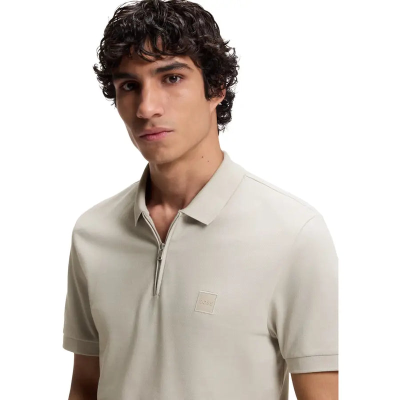 Polo beige pour homme, en coton, à manches courtes et fermeture éclair, orné d'un discret écusson logo de la marque.