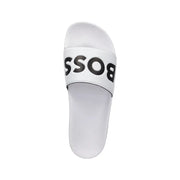 Pantoufles blanches pour homme avec logo noir imprimé en gras sur une bride en PVC, conçues pour le printemps et l'été.