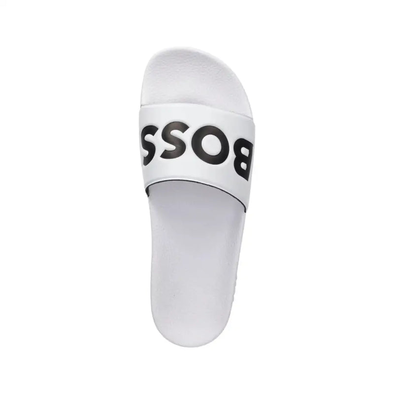 Pantoufles blanches pour homme avec logo noir imprimé en gras sur une bride en PVC, conçues pour le printemps et l'été.