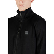 Pull à col roulé en laine Boss pour homme, noir, avec col côtelé et discret écusson de la marque, vue de face