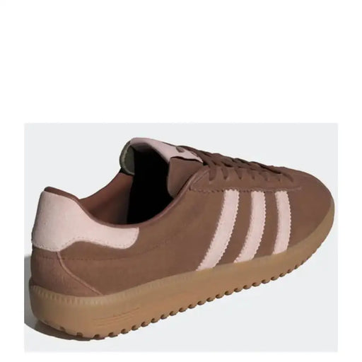 Brown Adidas sneaker with pink stripes displayed in a product image
