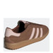 Brown Adidas sneaker with pink stripes displayed in a product image
