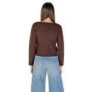 Women wearing a brown long-sleeved V-neck buttoned cardigan with wide-leg blue jeans