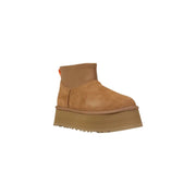 Brown platform UGG boot in tan suede with chunky sole and orange pull tab shown from the back side