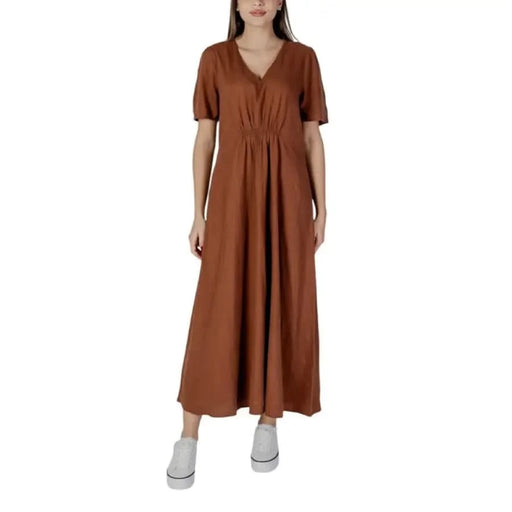 Robe longue marron à col V présentée dans une robe courte noire à col V par B.young