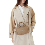 Beige leather Calvin Klein zippered womens handbag with prominent CK logo measuring 22 by 12.5 by 7 centimeters