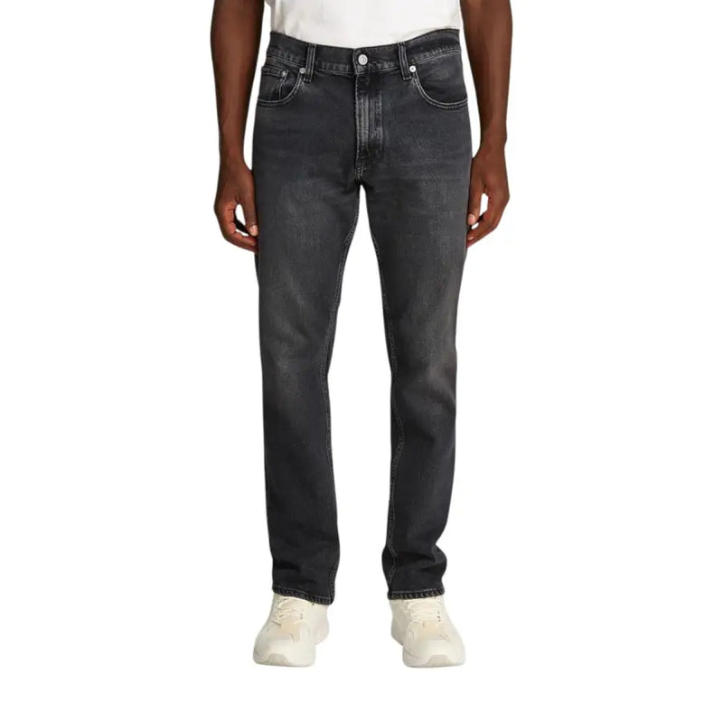 Black slim fit jeans with white stitching and button closure, made of denim material.