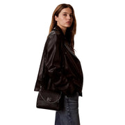 Calvin Klein black polyurethane leather crossbody handbag with silver chain shoulder strap and logo clasp