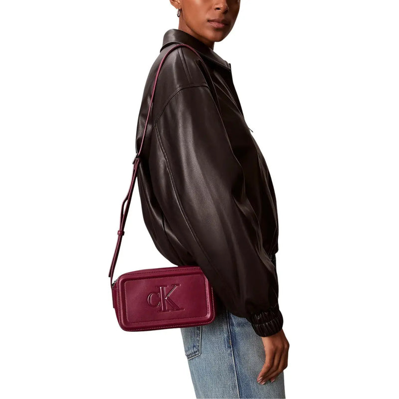Calvin Klein burgundy polyurethane crossbody bag with embossed ck logo and interior pockets for organized storage