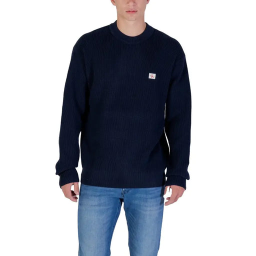 Pull bleu marine à col rond avec petit logo blanc sur la poitrine, en coton.