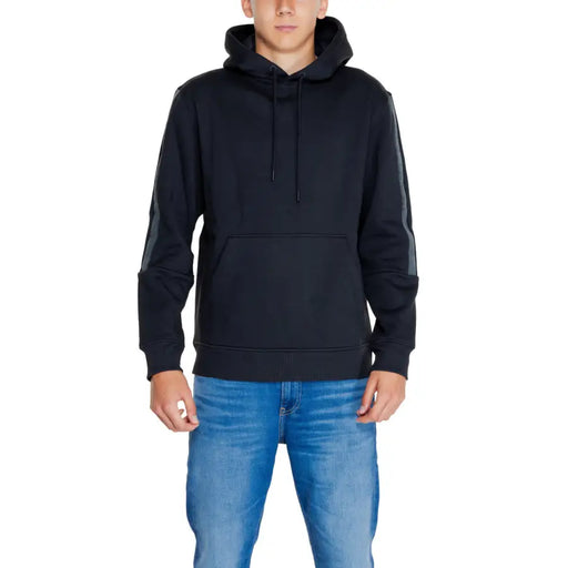 Men’s black hooded sweatshirt paired with light blue jeans from Calvin Klein Jeans
