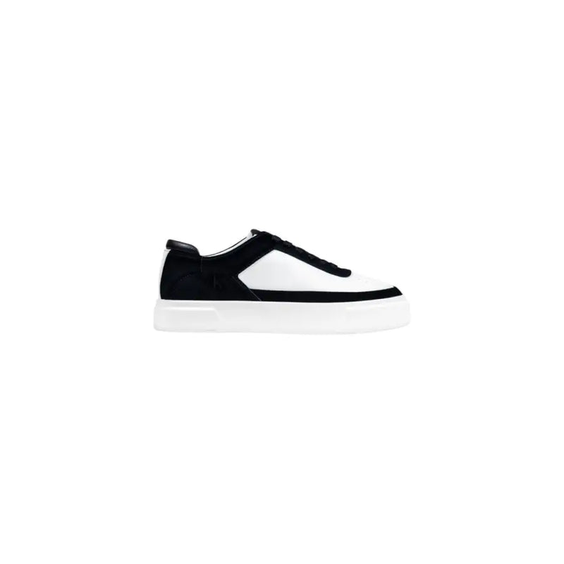 Black and white platform sneaker with velcro strap, textured upper material.