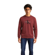 Calvin Klein Jeans Pull en coton bordeaux pour homme, orné du logo CK noir entrelacé et du nom de la marque (vue de face).