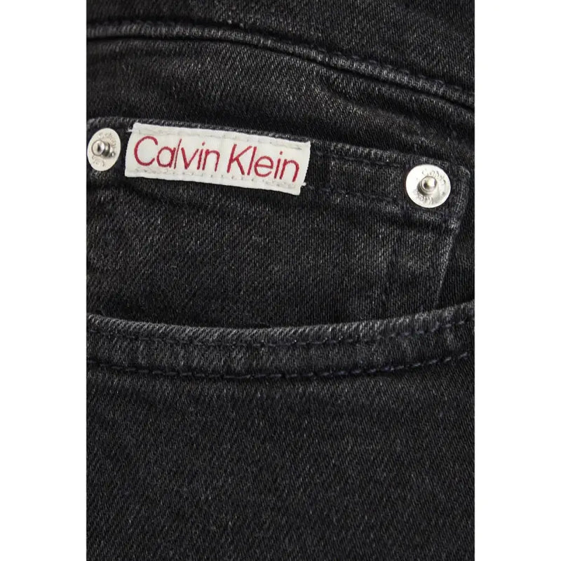 Jean slim en denim de coton noir pour homme avec un liseré blanc Calvin Klein étiquette avec lettrage rouge et rivets argentés