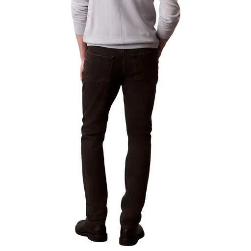 Jean Calvin Klein pour homme, noir, en coton stretch, délavage foncé, coupe slim, dos dévoilant les poches classiques.