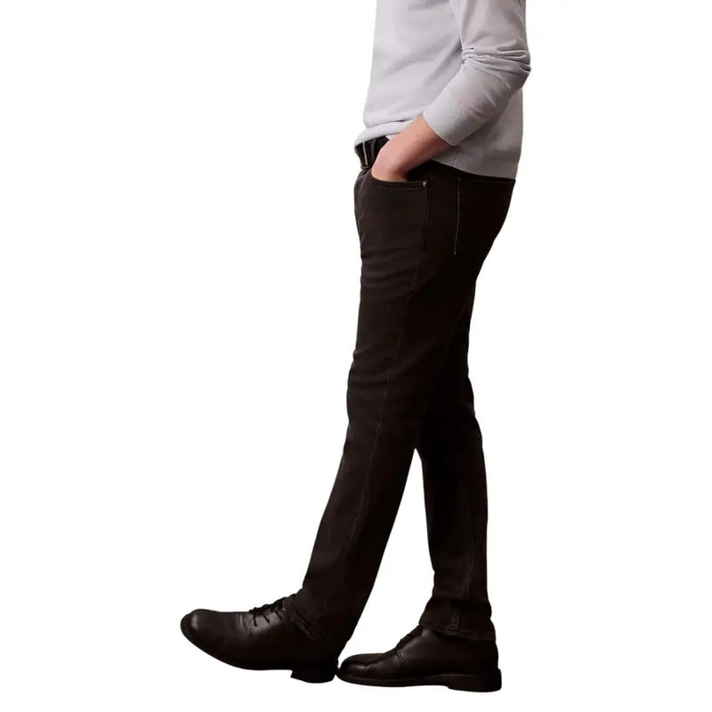 Calvin Klein jean homme noir en coton stretch coupe slim, délavage foncé, porté en tenue décontractée