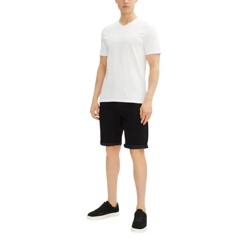 White v-neck t-shirt with black shorts and black sneakers.