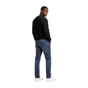 Jean en denim brut à cinq poches classiques et délavage subtil aux cuisses, associé à un sweat-shirt noir en coton Calvin Klein pour homme